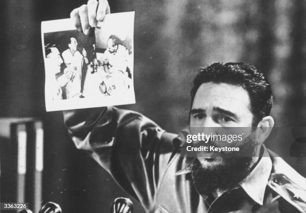 Cuban Prime Minister Fidel Castro, presents a photograph in which General Ovando Candia and other men of the Bolivian Army get drunk to celebrate the...