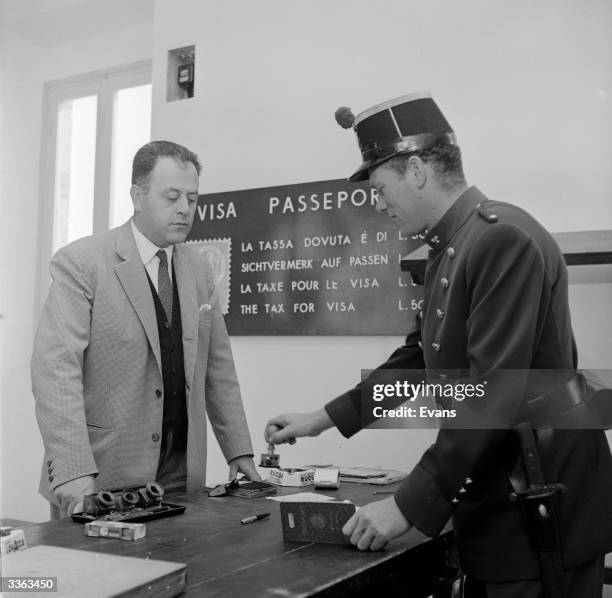Border guard stamping a visitor's passport as he enters San Marino, one of the world's smallest countries.