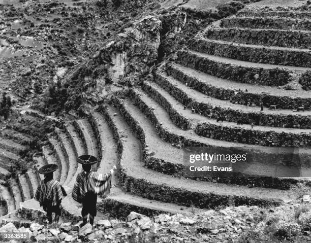 Two Peruvians at Pisac, with terraced fields created by the Aztecs in Peru.