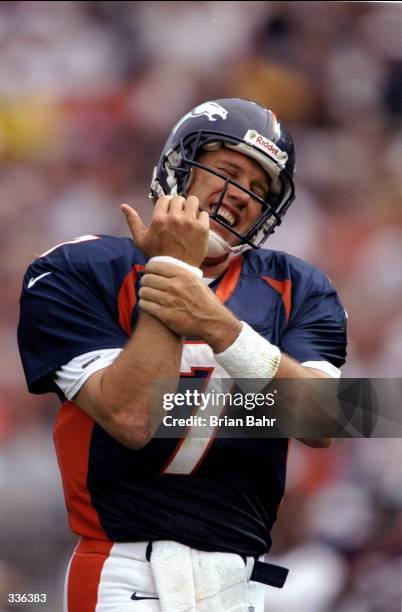 Quarterback John Elway of the Denver Broncos holds his wrist during a pre-season game against the Green Bay Packers at the Mile High Stadium in...