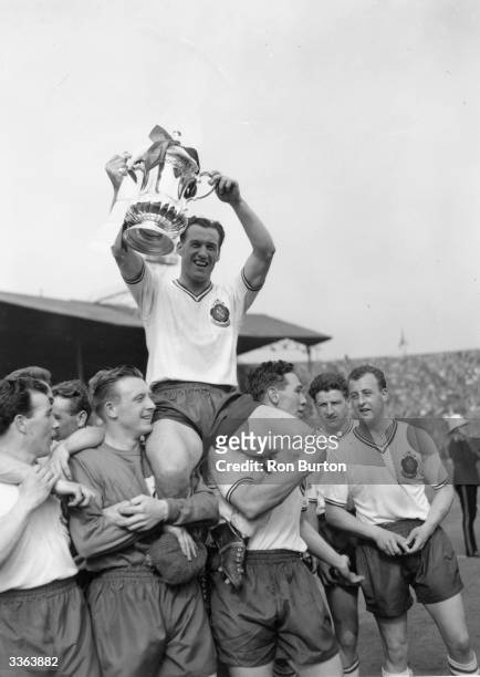 Bolton Wanderers captain Nat Lofthouse sits on the shoulders of his team mates as he lifts the FA Cup trophy, after their 2-0 victory over Manchester...