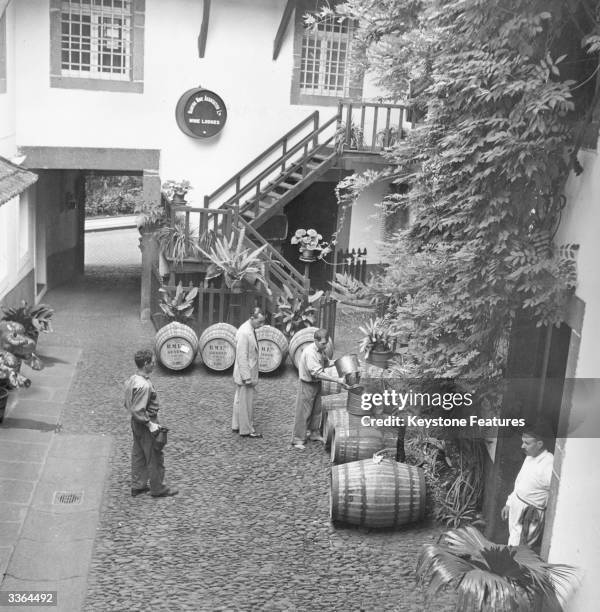 In the courtyard of a Madeira winery matured wine is poured into barrels for export. These barrels are marked to go to Geneva in Switzerland.