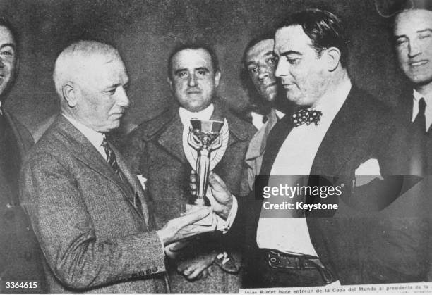 Jules Rimet, president of FIFA , presents the first World Cup trophy to Dr Paul Jude, the president of the Uruguayan Football Association, after...