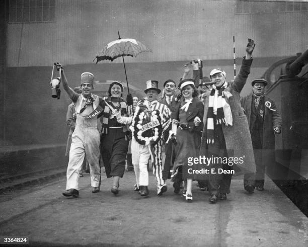 Arsenal football supporters cheer on the platform at King's Cross Station, London, as they make their way to Huddersfield for their team's FA Cup...