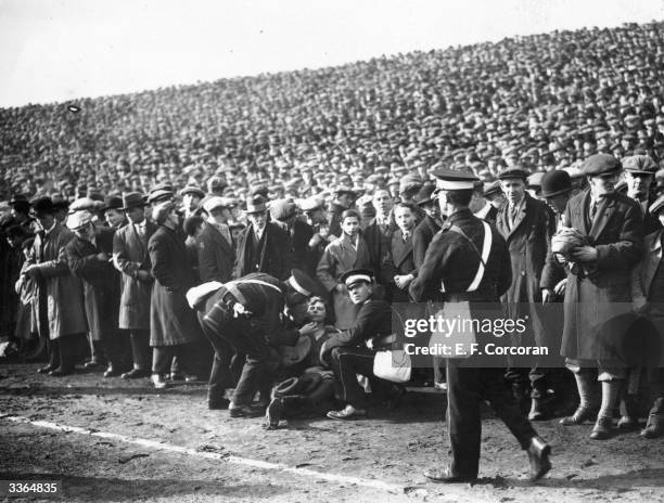 Woman who has fainted receives medical attention on the pitch sidelines during the FA Cup Semi-Final between Sheffield Wednesday and Huddersfield...