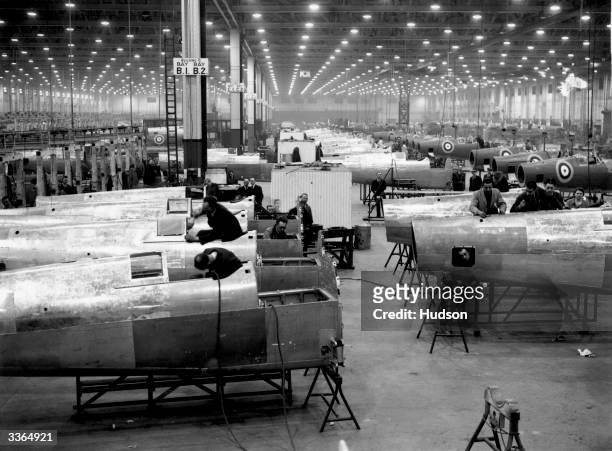 Workers in the assembly area of an aircraft factory in the Midlands, building spitfires.