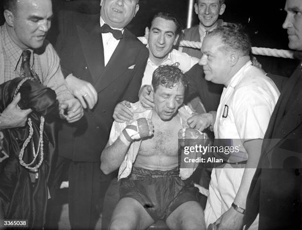 Heavyweight boxer Gus Lesnevich nurses his injuries after winning a fight against Freddie Mills.