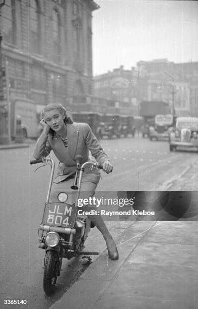 Rank starlet Susan Shaw on a Corgi scooter. It has a 98cc two-stroke engine, weighs 95 lbs, does 120mpg and 30 mph. Original Publication: Picture...