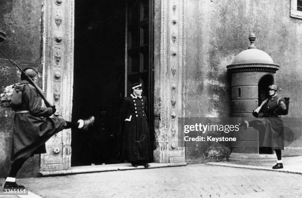 Guards patrol with a high stepping style , known as the 'Roman Step', outside the Palazzo Venezia, home of fascist Italian dictator, Benito Mussolini.