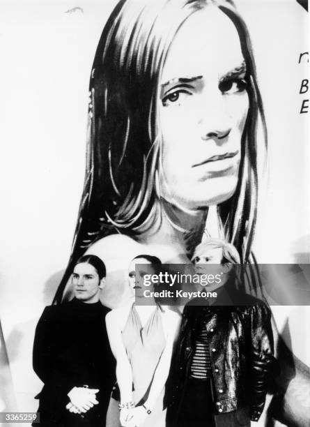 Pop Art's leading light, Andy Warhol , attends the German premiere of his film 'Trash'. With him, in front of one of the film's promotional posters,...