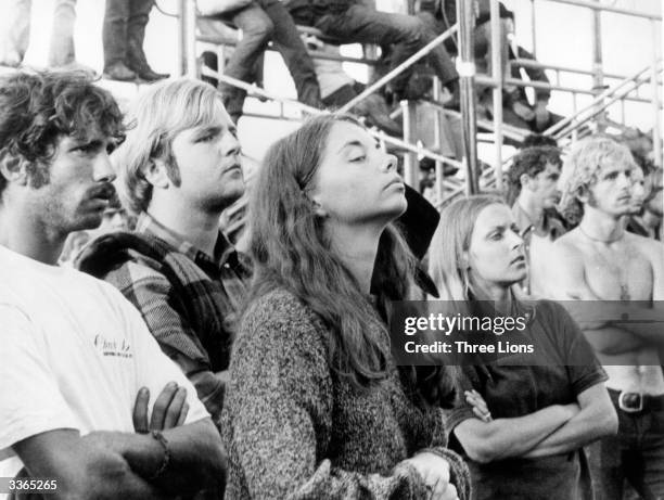 Group of people listening to the music at the Woodstock Music and Arts Fair and enjoying the relaxing atmosphere.