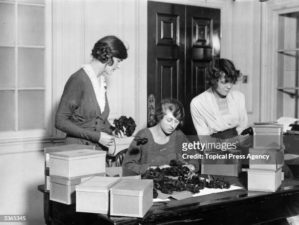 Group of volunteers packing artificial Armistice Day poppies, which will be sold in aid of ex-servicemen and women, October 1921.