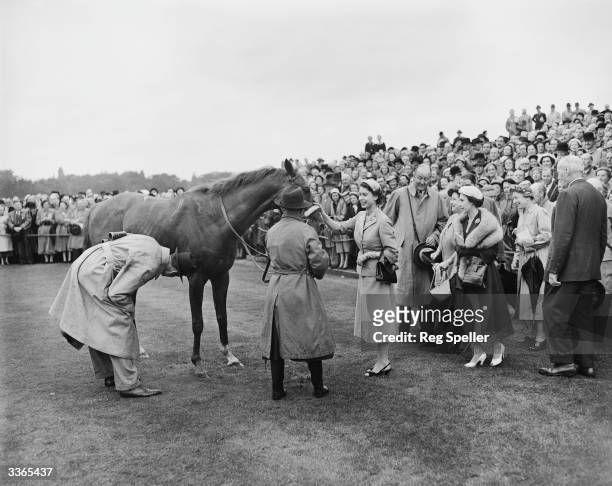 Queen Elizabeth II patting her horse, Aureole after it came in first at the Royal Ascot race meeting on Ascot Heath, Berkshire. Princess Margaret...