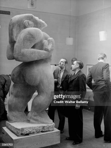 Visitors to a gallery study 'Adam', a piece by American-born British sculptor Jacob Epstein .