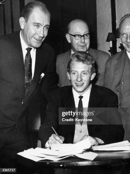 Denis Law signs for Manchester City FC at Hudderfield watched by Les McDowall and Doug Hamer . Manchester City FC and Scottish International soccer...