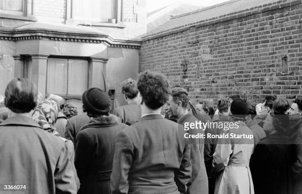 Although there is little to see, crowds of the curious gather outside 10 Rillington Place, the home of mulitiple murderer John Christie and scene of...