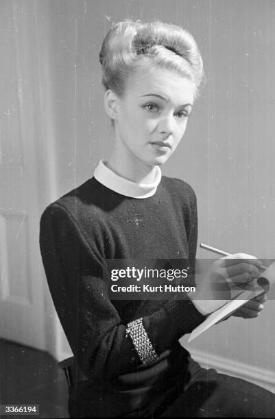 The English actress Susan Shaw models a hand-knitted black woollen jumper with detachable white collar. Original Publication: Picture Post - 4482 -...