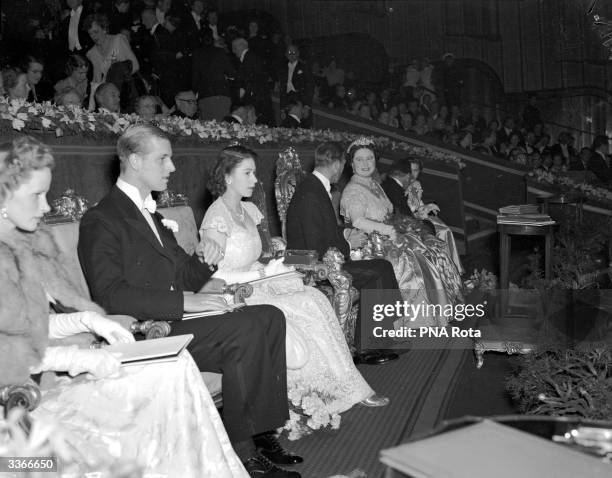 King George VI and Queen Elizabeth with Princess Elizabeth and Philip, Duke of Edinburgh in the Royal Box at The Odeon, Leicester Square, London at a...