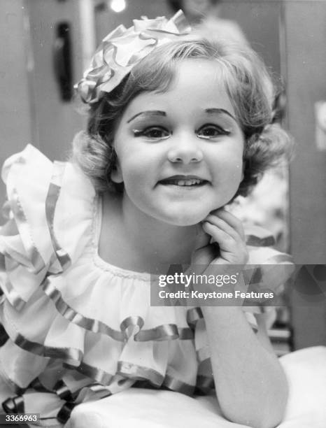 Young girl ready to appear in the Sydney Eisteddfod wearing stage make up and dressed in a flounced dress.