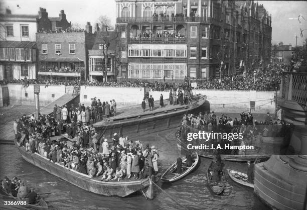 Crowds of spectators line the barges and tow path at Hammersmith, London, for the annual Oxford V Cambridge University Boat Race.