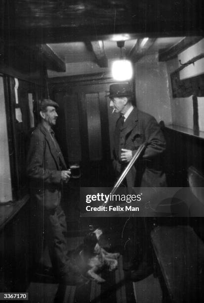 Tom Wansborne, gamekeeper's assistant, has a pint of mild-and-bitter with Charles Chandler, gamekeeper to the Eridge Estate, in the 'Crest and Gun'...