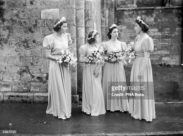 From left to right, Pamela Mountbatten, Princess Alexandra of Kent, Princess Margaret and Princess Elizabeth stand outside Romsey Abbey, Hampshire in...