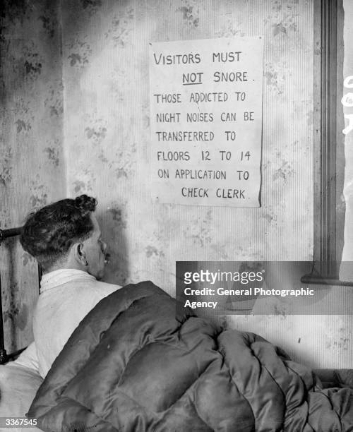 Handwritten sign tacked onto the wall of a grubby hotel room warns the occupant that snoring is forbidden.