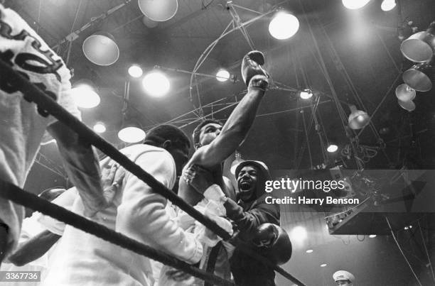 American boxer Cassius Clay, later Muhammad Ali, celebrates his win over Sonny Liston in their heavyweight title fight at Miami Beach, Florida. Clay...