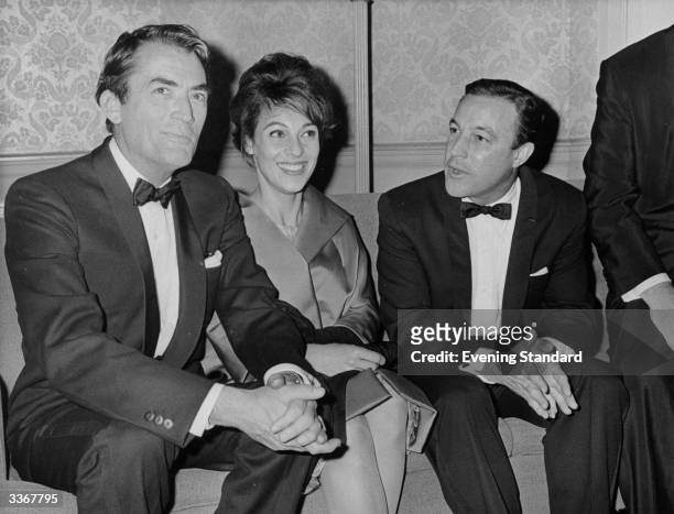 American screen star Gregory Peck and his wife Veronique sit with dancer and actor Gene Kelly at the Astoria, London.