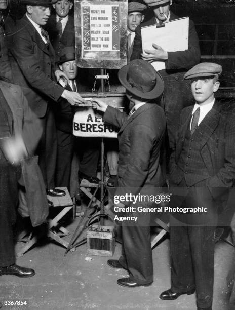 Man placing a bet with a bookmaker at a greyhound race track.