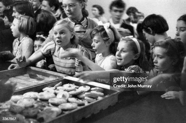 Hungry Children reaching for some cakes after dancing lesson at the Caledonian Hall, Islington, London. Original Publication: Picture Post - 7420 -...