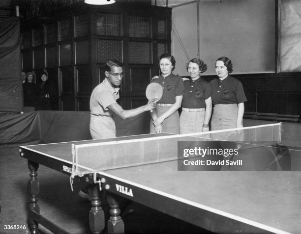 Ayub, captain of the Indian table tennis team, demonstrating his master stroke to three members of the Belgian ladies' team before the opening of the...