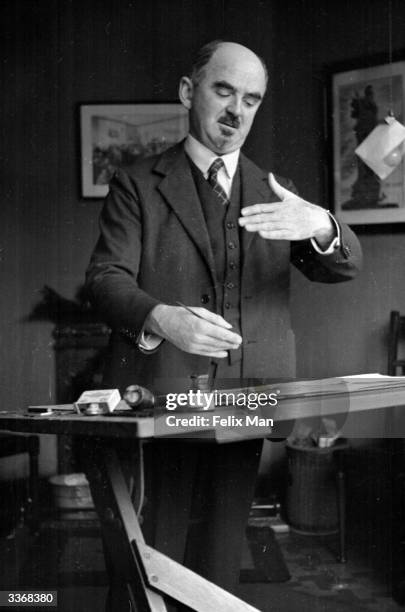 The British political cartoonist David Low at work in his studio in London drawing cartoons for the 'Evening Standard' newspaper. Original...