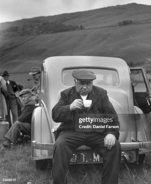 Spectator drinking a cup of tea at a hound trail race at Troutbeck in the Lake District. Original Publication: Picture Post - 5396 - Hound Trailing -...