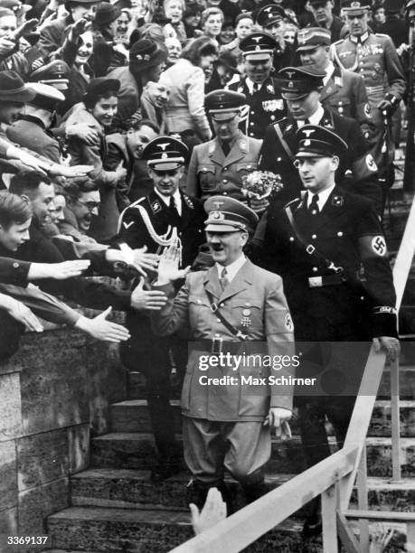 Adolf Hitler, Fuehrer of Germany's Third Reich, enjoying an ecstatic reception at the Olympic Stadium, Berlin, as he arrives to address 132,000...