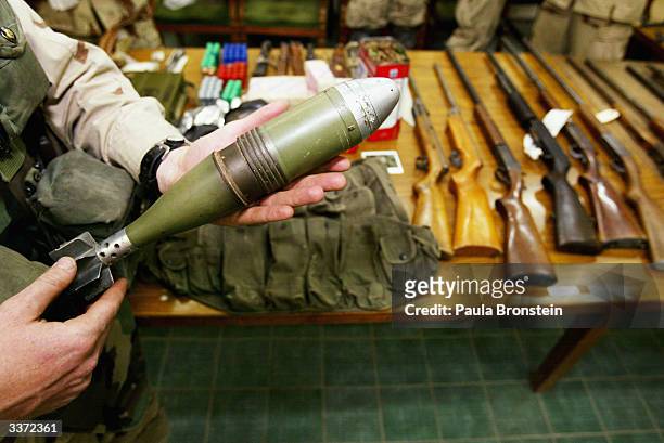 The Iraqi Civil Defense Company looks over a display of weapons confiscated by the U.S. Army 1-36 Infantry Task Force during a house to house search...