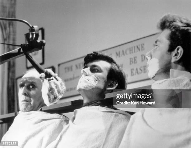 Machine which can shave a dozen men at the same time lathers the faces of a row of actors on an untransmitted pilot show for a proposed television...