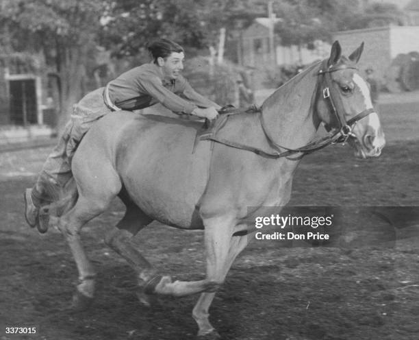 National serviceman riding lying down in 'pillion position; at RASC, Buller Barracks in Aldershot where training for the Royal Tournament takes place.