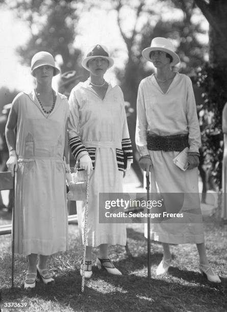 Long waisted summer dresses worn with cloche hats. Two bar shoes, gloves, walking sticks and clutch bags complete the outfits.
