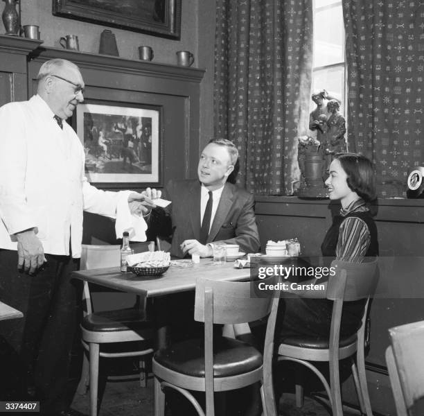 Couple paying for their meal at Ye Olde Chop House, New York, with an American Express Credit Card.