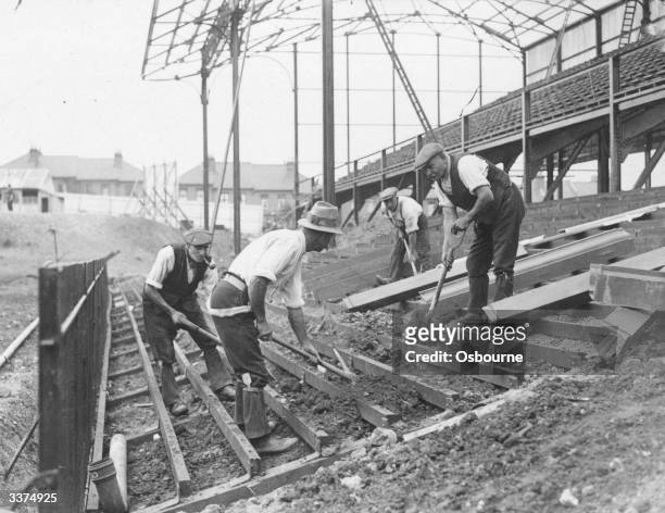Men at work building terraces at Crystal Palace FC ground, Norwood, south London.