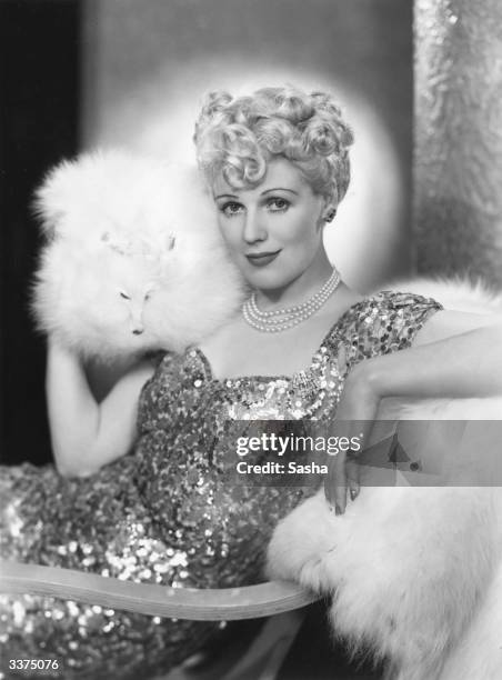 British character actress Enid Stamp-Taylor wearing a silver fox fur and sequined dress.