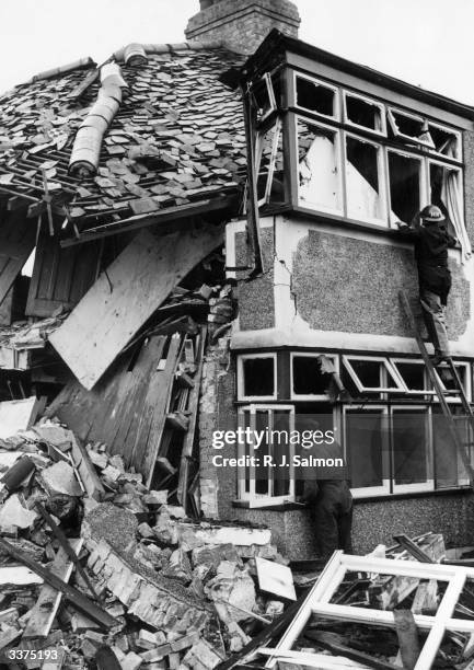 Civil Defence men at work on a bomb damaged house in London.