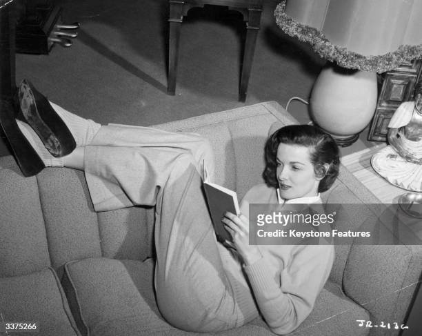 American actress Jane Russell reading at home.