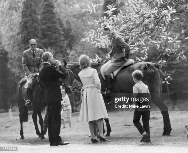 Queen Elizabeth II and Prince Philip on horseback in Windsor Great Park, stopping for a chat. Their son Prince Edward is on the right.