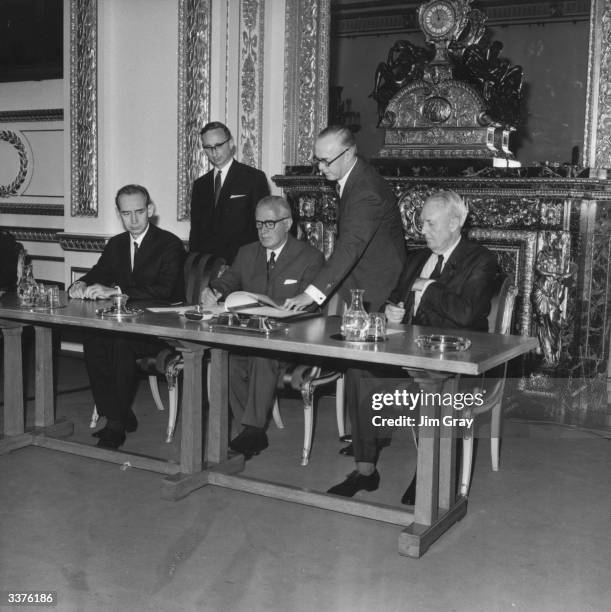 Britain's Foreign Secretary Michael Stewart signs the treaty on the Non-Proliferation of Nuclear Weapons at Lancaster House, London, watched by the...