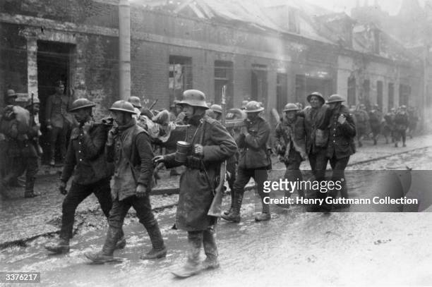 Wounded British and German troops in the streets of St Quentin, France, after the Second Battle of the Somme.