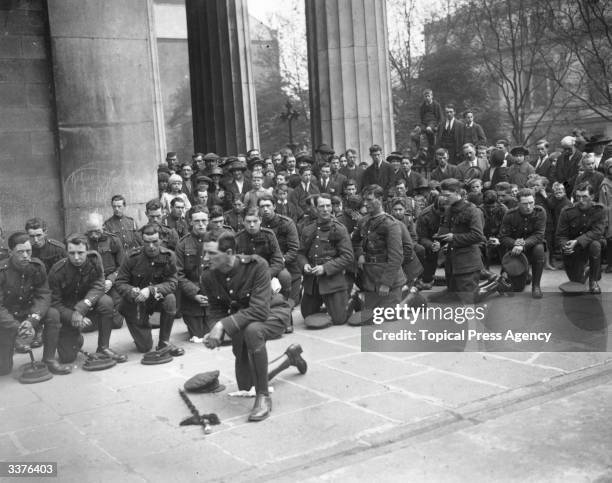 Members of an Irish National Army band kneeling in prayer at a special Requiem Mass at the Pro Cathedral, Dublin, on the first anniversary of the...