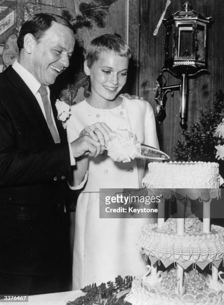 Singer Frank Sinatra and actress Mia Farrow cutting their wedding cake at Las Vegas.
