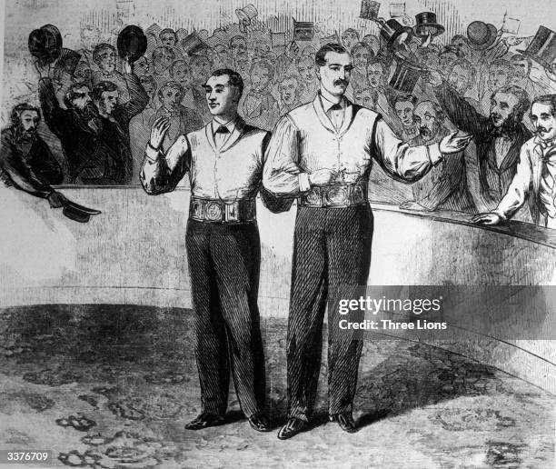 American boxer John C Heenan, right, and English boxer Tom Sayers both receive belts after the first international boxing championship, at an outdoor...